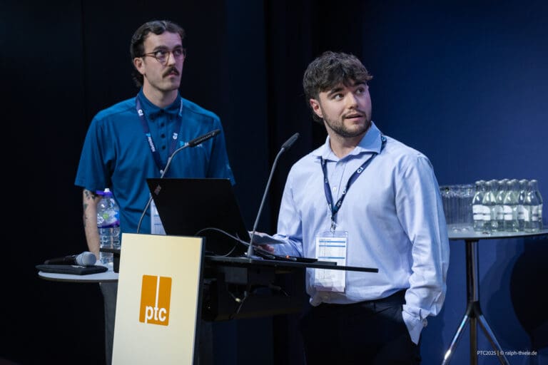 Image of two young males presenting at conference