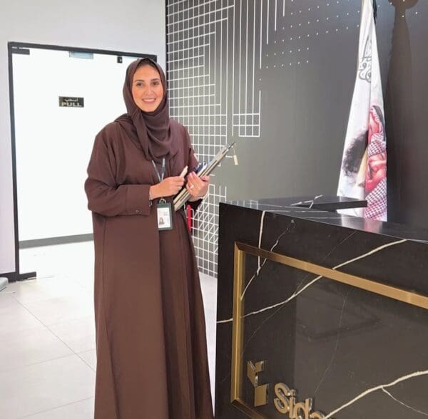 A woman standing at the front desk of an office