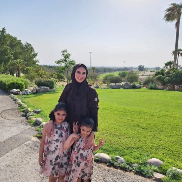 A woman with two young children standing outside