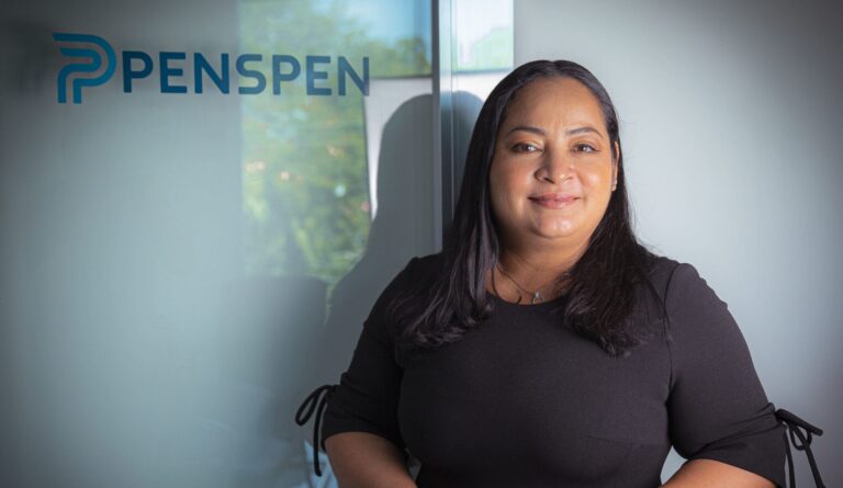 A woman stands in front of a wall that displays the Penspen logo