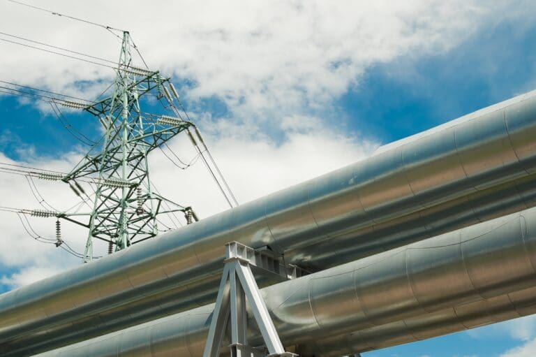 pipeline and power lines on the background of blue sky and clouds.